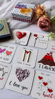 several small cards with different designs and words on them next to a bouquet of flowers