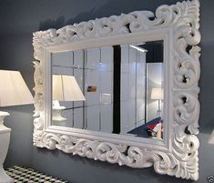 a large white mirror sitting on top of a wall