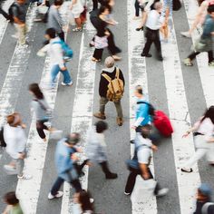 many people are crossing the street with their backpacks