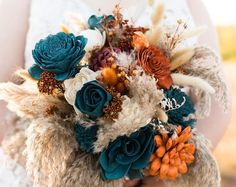 a person holding a bouquet with flowers and feathers