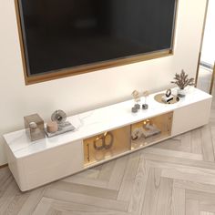 a white entertainment center with gold trim and two drawers on each side in front of a large flat screen tv