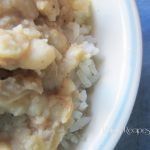 a bowl filled with food sitting on top of a blue table cloth covered in white rice