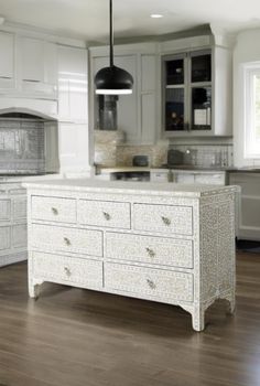 a kitchen with white cabinets and an island in the middle of the flooring area