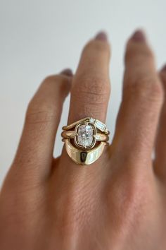 a woman's hand with a gold ring and diamond set on top of it