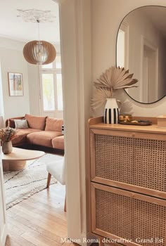 a living room filled with furniture and a large mirror on top of a wooden dresser