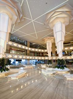 the interior of a large building with lights and decorations on the ceiling, along with marble flooring