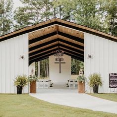 the inside of a white building with tables and chairs on it's front lawn