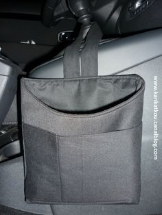 a black bag sitting on top of a car seat in front of a steering wheel