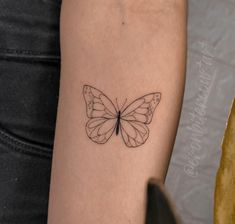 a small butterfly tattoo on the arm