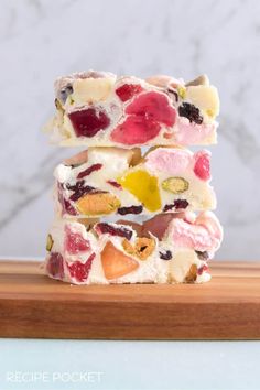 three pieces of fruit and white chocolate barkle stacked on top of each other in front of a marble background