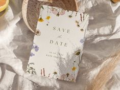 a save the date card sitting on top of a table next to sliced oranges