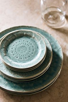 a stack of blue plates sitting on top of a table