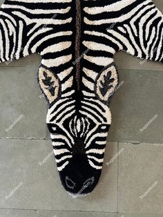 a zebra rug is laying on the floor with it's head down and eyes open