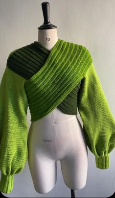 a mannequin with a green sweater on it's head and arms wrapped around the shoulders