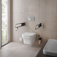 a white toilet sitting next to a bathroom sink under a window in a room with beige walls