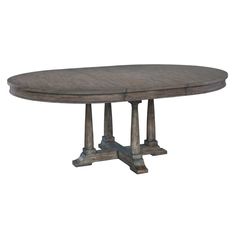 an oval dining table with two pedestals on one end and a round wooden top