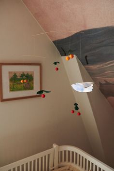 a baby's crib in a room with paintings on the wall and ceiling