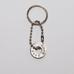 a metal keychain with the word love is written in white letters on it