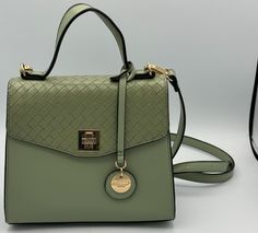 This Dune London satchel crossbody shoulder pistacio green purse is the perfect accessory for any occasion. The bag features a square shape with a clasp, toggle, and turn lock closure and is made of faux leather with a coated finish. It has a beautiful pistachio green handle/strap color and gold hardware color that accentuates its elegance. The bag is ideal for travel, weddings, parties, casual, formal, workwear, and business. It has multiple features including a cross-body strap, is lined, has bottom studs, inner zipper pocket, and strap is adjustable. The bag also comes with a bag charm that can be used to personalize it. This satchel crossbody shoulder bag purse is perfect for women who love to keep their belongings organized and be stylish. No International Shipping. Sage Green Purse, Formal Workwear, Green Purse, Dune London, Pistachio Green, Square Shape, Crossbody Shoulder Bag, Gold Hardware, Cross Body