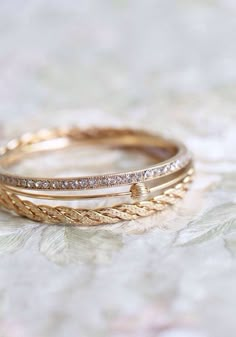 two gold wedding bands with diamonds on them