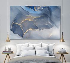 an abstract painting on the wall above a bed in a room with two nightstands