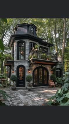 a very nice looking house in the middle of some trees and plants on top of it