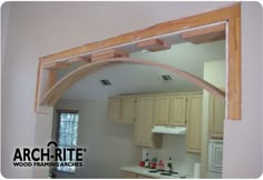 an arch in the middle of a kitchen that is being remodeled with wood trimming