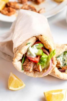 greek gyro chicken pita with tzatziki sauce and lemon wedges