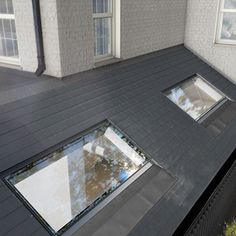 an aerial view of the roof of a house with two windows and a skylight