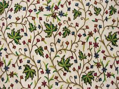 an intricately designed wallpaper with flowers and leaves on it's surface,