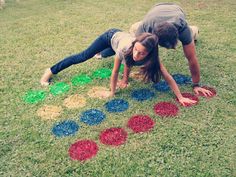 two people playing with colored circles in the grass