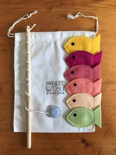 a bunch of different colored fish on a piece of white cloth with a wooden stick