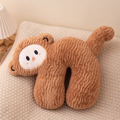 a brown teddy bear laying on top of a couch next to a lamp and pillow