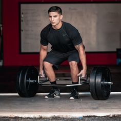 a man is squatting on a barbell