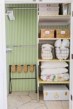 an organized closet with baskets and towels