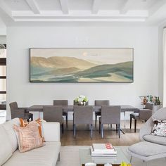 a living room filled with furniture and a painting hanging on the wall over a table