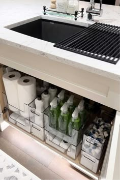 a kitchen sink filled with lots of toilet paper and cleaning supplies next to a counter top