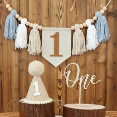 a table topped with two cakes covered in frosting and tassels next to a wooden wall