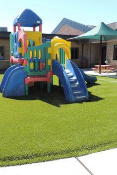 a colorful playground set in the middle of a lawn