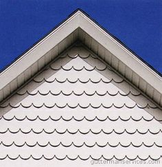 the corner of a house with a blue sky in the back ground and white roof