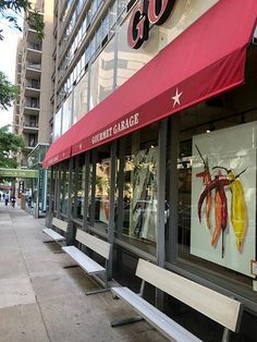 a storefront with red awnings on the side of it