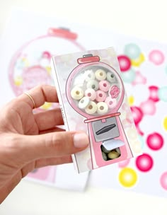 a person is holding up a small toy machine with buttons in it's mouth