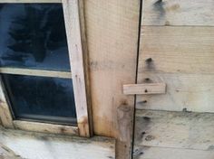 an open window on the side of a wooden building