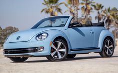 a blue convertible car parked in front of palm trees