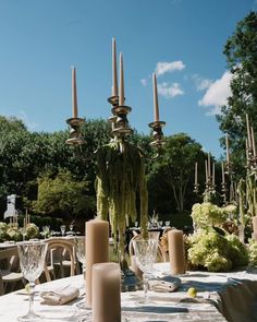 an outdoor dining table with candles and plates