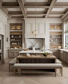 a large kitchen with wooden floors and white cabinets, an island bench in the middle