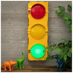 a traffic light sitting next to two toy dinosaurs