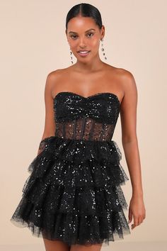 The Lulus Illustrious Glow Black Sheer Tulle Sequin Tiered Mini Dress is perfect for any occasion that calls for extra extravagance! This sensational dress features a sparkling sequin design across the tulle-mesh construction that shapes a strapless, bustier-inspired bodice with sheer mesh paneling (along with supportive boning), a gathered bust with padded cups, and a sweetheart neckline with hidden no-slip strips. The high, fitted waist sits atop a fun and frilly tiered skirt that finishes at Black Dress Glitter, Strapless Bustier, Tiered Mini Dress, Sequin Design, Black Sequin Dress, Bustier Dress, Date Night Dresses, Sequin Mini Dress, Sheer Dress