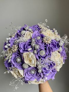 a bridal bouquet in purple and white with pearls, diables and jewels