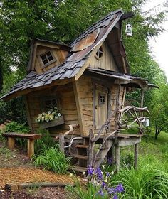 a small wooden house sitting on top of a lush green field